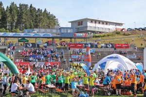 Begeisterte Teilnehmer und Zuschauertribühne beim Thüringer Wald Firmenlauf in der DKB SKI ARENA Oberhof