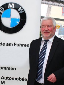 Peter Matthes vom BMW Autohaus Matthes neben Firmenschild