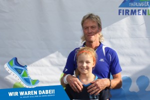 Teilnehmer mit Kind vor der Fotowand beim Thüringer Wald Firmenlauf 2016 in der DKB-Ski-Arena Oberhof