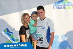 Teilnehmer vom Team der Schwenninger Sparkasse mit Familie vor der Fotowand beim Thüringer Wald Firmenlauf 2016 in der DKB-Ski-Arena Oberhof