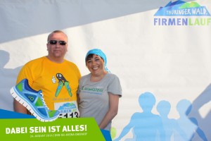 Teilnehmer vom Team Schlüter Baumaschinen und Teilnehmerin vom Team Stiftung Rehabilitationszentrum Thüringer Wald vor der Fotowand beim Thüringer Wald Firmenlauf 2016 in der DKB-Ski-Arena Oberhof