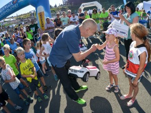 Geschäftsführer vom Autohaus Matthes gratuliert der Siegerin des Bobbycar- und Maskottchenrennens beim Thüringer Wald Firmenlauf 2016