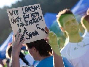 Besucherin vom Thüringer Wald Firmenlauf 2016 mit einem Schild mit der Aufschrift: Wer langsam läuft hat mehr vom Startgeld