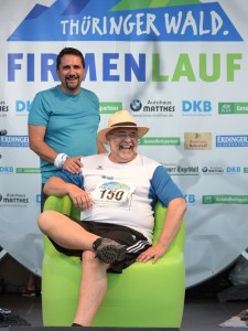 Teilnehmer vom Thüringer Wald Firmenlauf 2016 vor der Sponsorenwand